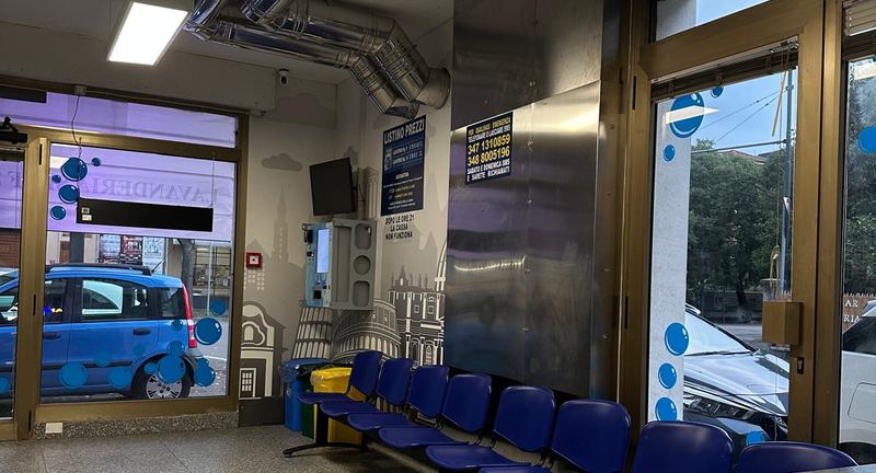 Sedute di attesa nella lavanderia Express Wash di via Cesare Costa